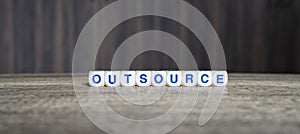 Outsource boggle word cubes on dark background photo