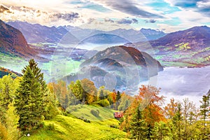 Outstanding autumn view on suburb of Stansstad city and Lucerne lake with mountaines and fog