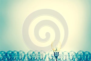 Outstanding creative idea background concept . one Light bulb glowing among a group light bulbs.vintage color tone