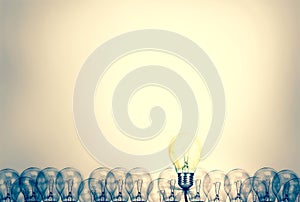 Outstanding creative idea background concept . one Light bulb glowing among a group light bulbs.vintage color tone