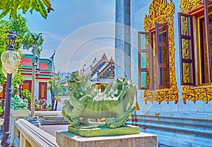 The outstanding stone Singha statue, traditional chinese fu dog guardian in  buddhist tempes, Wat Bowonniwet Vihara in Bangkok,