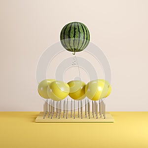 Outstanding watermelon floating with yellow balloon above nail traps on yellow pastel background color