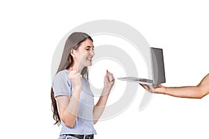 Outstretched person hand holding a laptop showing the screen to a joyful young woman isolated on white background. Girl