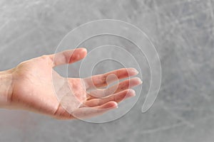 Outstretched woman`s palm on grey background. Hand close-up. photo