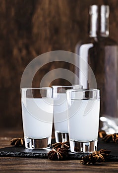 Ouzo - Greek anise brandy, traditional strong alcoholic drink in glasses on the old wooden table, place for text