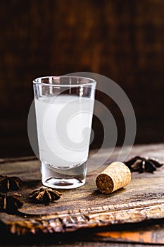 Ouzo or Uzo, is a Greek anise brandy, traditional strong alcoholic drink in glasses on the old wooden table. Greek tradition,