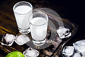 Ouzo or Uzo, is a Greek anise brandy, traditional strong alcoholic drink in glasses on the old wooden table. Greek tradition,