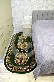 Oval bedside mat in modern bedroom interior