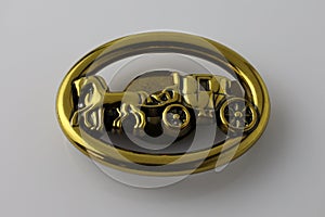 Oval brooch with horses and carriage. Metallic gold decoration for a bag on a white background.