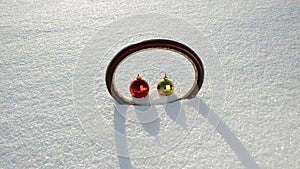 Oval frame and two Christmas balls on winter snow