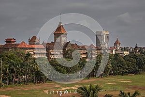 Oval maidan prctising cricet and in backgraund british time heritage buildings Mumbai