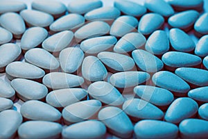 Oval pill blue pills on a flat surface - Potency pharmacology - close up view