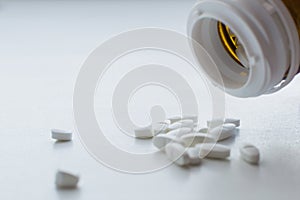 Oval pills spilling and dropped out of pill bottle