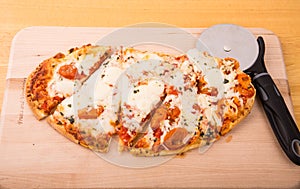 Oval Pizza Sliced on Wood Board