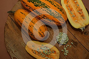 Oval pumpkin lies on a wooden table