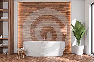 Oval white bathtub in modern bathroom with wood look tiles