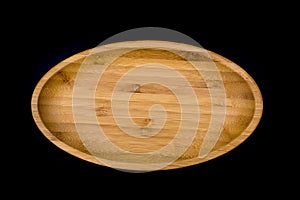 Oval wooden plate on black background