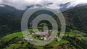 OVARO MIONE, ITALY - APRIL, 2023: Aerial drone view of a valley in the morning with clouds. Small mauntain village Mione