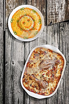 Oven Baked Vegetable Stew with Chicken Meat and Bowl of Garnished Russian Salad set on Old Weathered Garden Wooden Table
