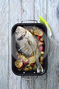 Oven baked whole sea fish with green olives, cherry tomatoes and herb butter.