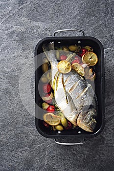 Oven baked whole sea fish with green olives, cherry tomatoes and herb butter.