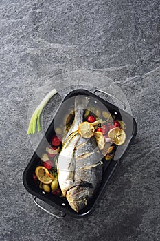 Oven baked whole sea fish with green olives, cherry tomatoes and herb butter.