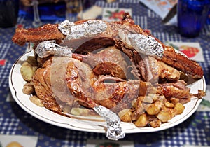 Oven-roasted goose with apples, cut into chunks. celebratory dish served to the table on an elegant porcelain plate. with clipping