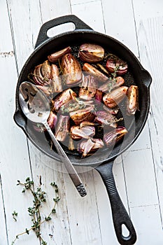 Oven roasted red onions with thyme in a cast iron frypan.