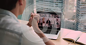 Over businessman shoulder laptop view partners involved in videoconference negotiations