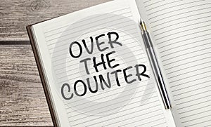 OVER THE COUNTER text on a notepad with pen, business