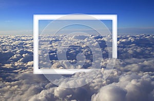 Over cumulus clouds bright landscape view from the window of an airplane with a white frame photo