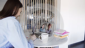 Over shoulder closeup view of remote employee conferencing in online group virtual chat on laptop screen. Company staff