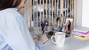 Over shoulder closeup view of remote employee conferencing in online group virtual chat on laptop screen. Company staff