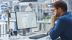 Over the Shoulder Shot of Engineer Working with CAD Software on Desktop Computer, Screen Shows Tec