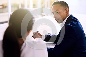 Over the shoulder shot of handsome businessman during executive meeting