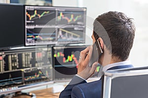 Over the shoulder view of computer screens and stock broker trading online. photo