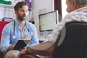 Male doctor prescribing medicament  to senior man in clinic