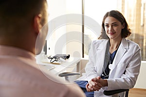 Over The Shoulder View Of Man Having Consultation With Female Doctor In Hospital Office