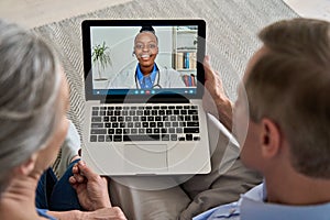 Over shoulder view of old couple patient video calling virtual doctor on laptop. photo