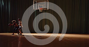 Overall Two young basketball players play basket ball competition amateurs hall sports parquet silhouettes dribbling