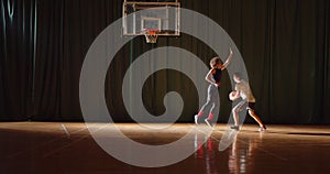 Overall Two young basketball players play basket ball competition amateurs hall sports parquet silhouettes dribbling