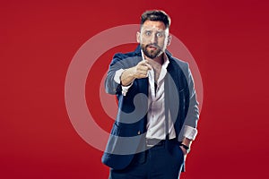 The overbearing businessman point you and want you, half length closeup portrait on red background.