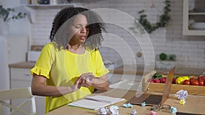 Overburdened African American young woman tearing page and crumpling paper. Portrait of overworked beautiful sad