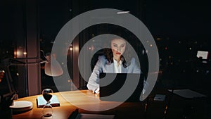 Overburdened woman working office closing tired eyes looking laptop at night.