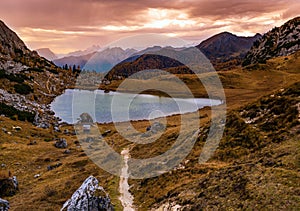 Overcast morning autumn alpine Dolomites mountain scene. Peaceful Valparola Path and Lake view, Belluno, Italy