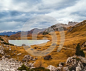 Overcast morning autumn alpine Dolomites mountain scene. Peaceful Valparola Path and Lake view, Belluno, Italy