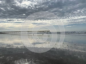 Overcast morning beach scene with pier