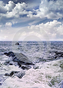 Overcast seashore with rocks and wild splashing waves, Sanya, China