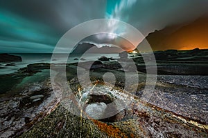 Overcast sky lit by Aurora Borealis over the famous rock formation, Dragon\'s Eye