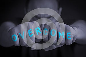 OVERCOME written on an angry manâ€™s fists